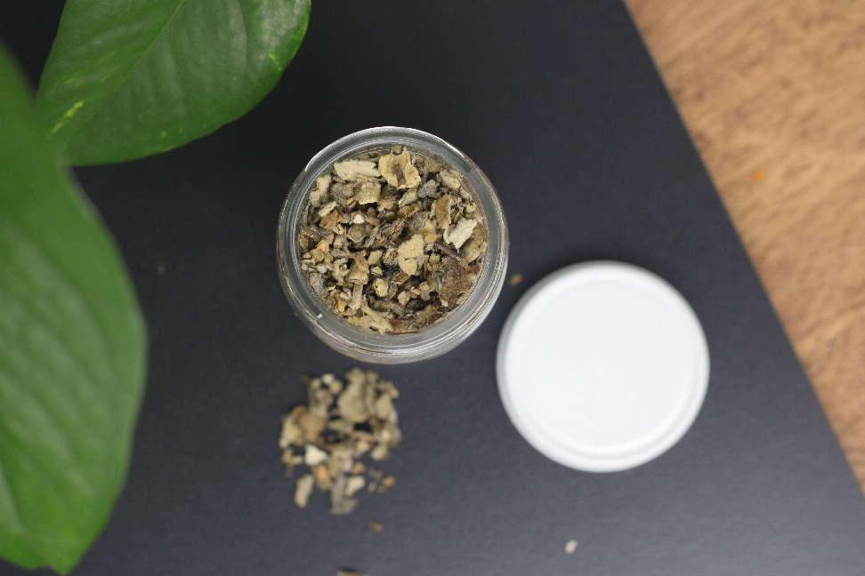 Dried organic mullein leaf flakes in small clear container with white lid
