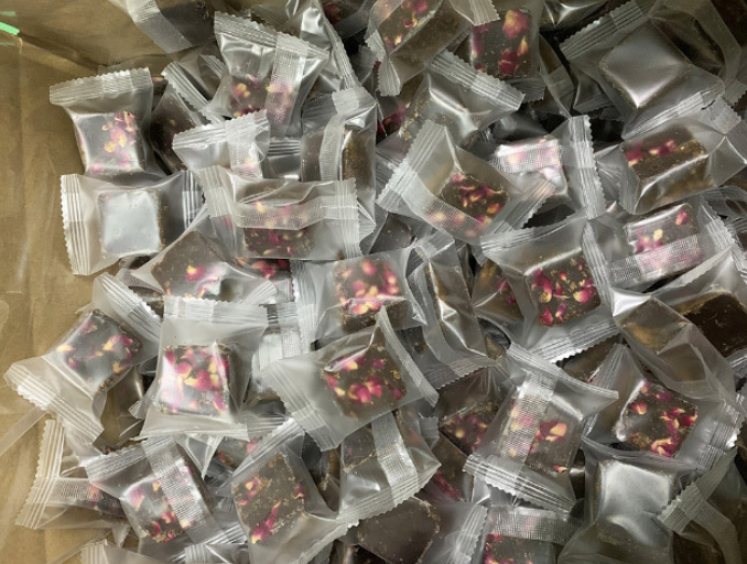 Foil-wrapped brown sugar cubes with visible flower and fruit pieces