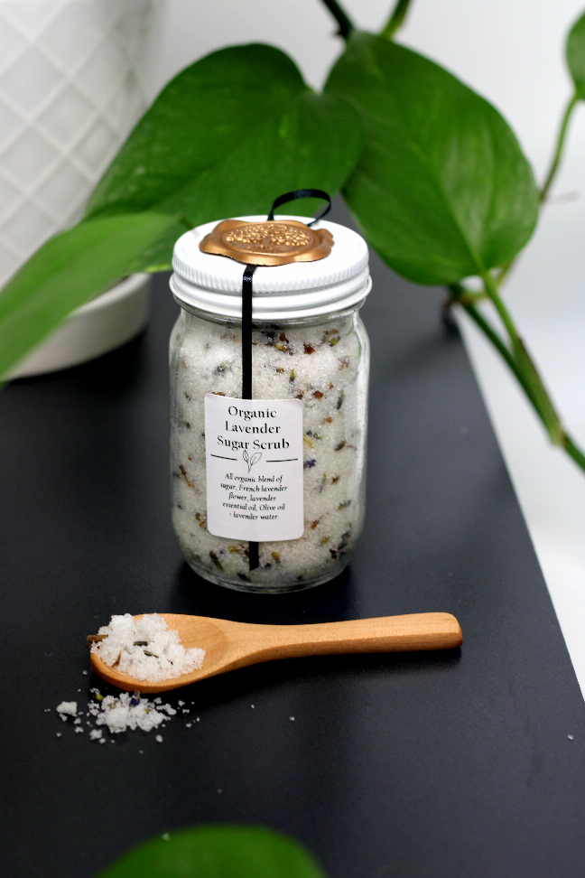 Organic lavender sugar scrub jar with gold seal, label, and wooden spoon