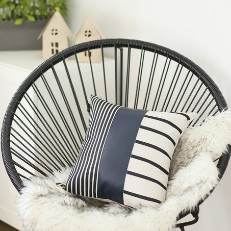 Throw pillow cover with navy-blue center panel and black-and-white striped front
