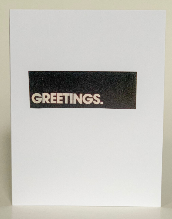 Anytime greeting card cover with centered 'GREETINGS.' on black speckled band
