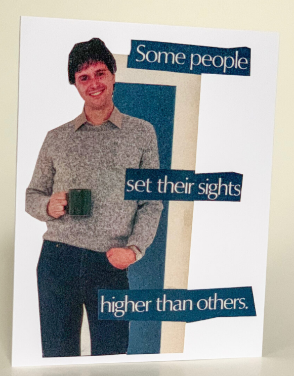 Greeting card front showing illustrated man with mug and blue text: “Some people set their sights higher than others.”