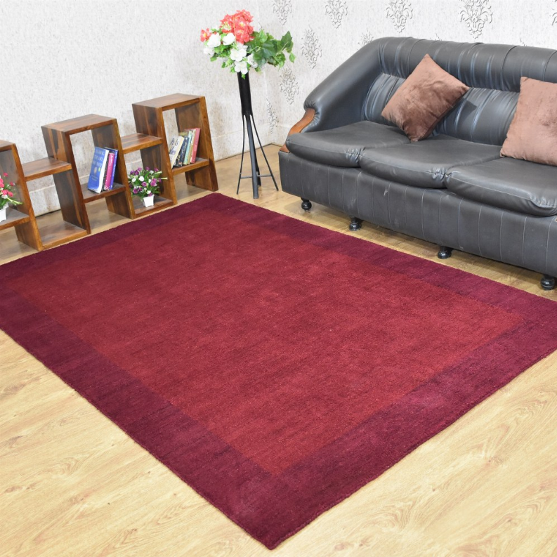 Burgundy contemporary area rug with smooth low pile, flat and neatly edged.