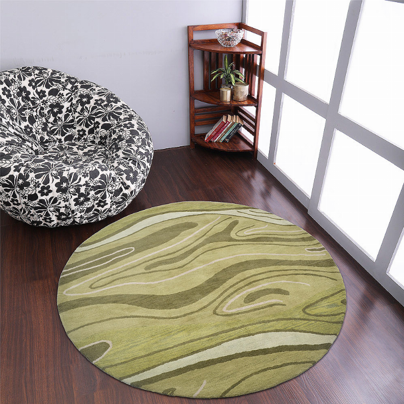 Round abstract area rug in sage green with light cream swirl lines and curved motif