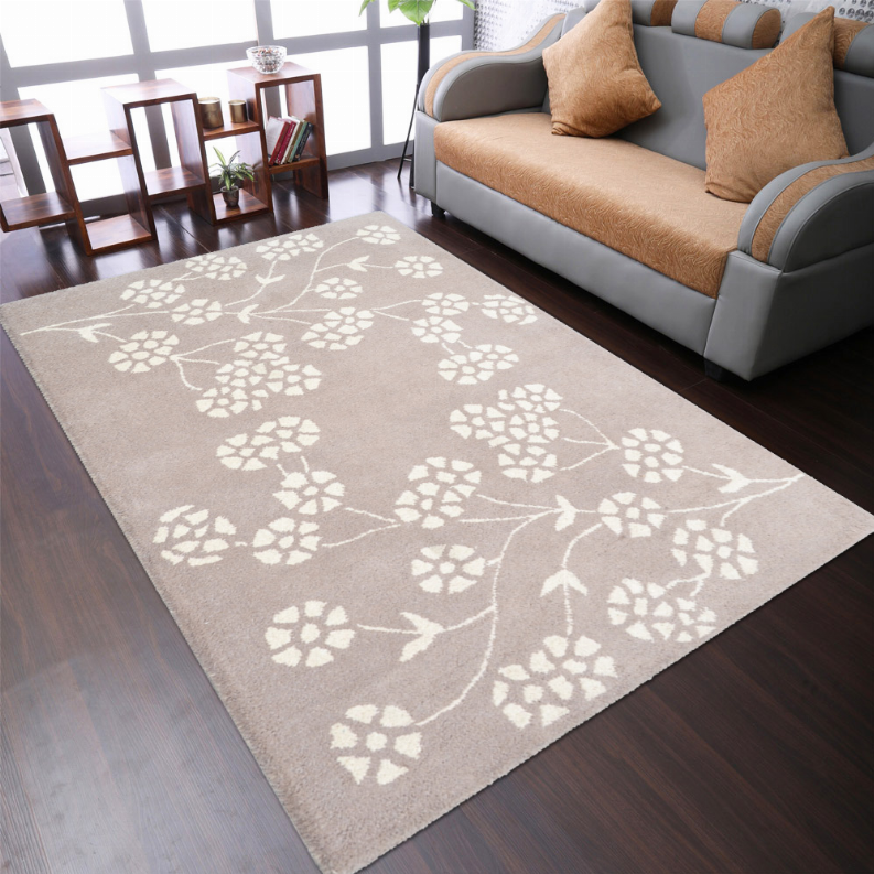 Taupe hand-tufted wool area rug with white floral vine pattern, placed on floor