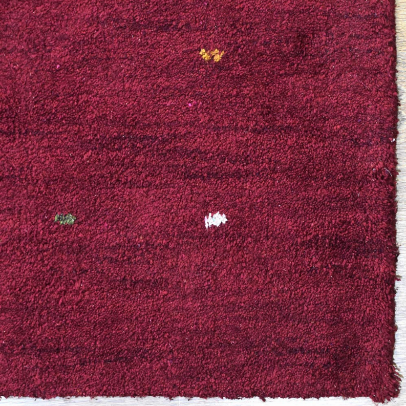 Burgundy area rug with dense shag texture, rectangular pile