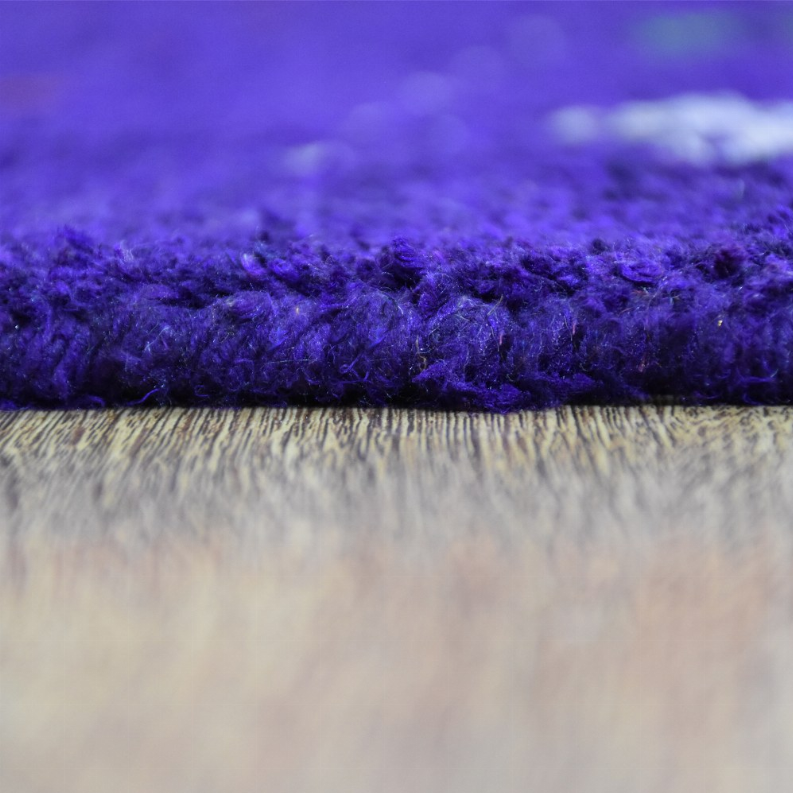 Hand-knotted silk mix area rug, dense purple pile with visible rug edge