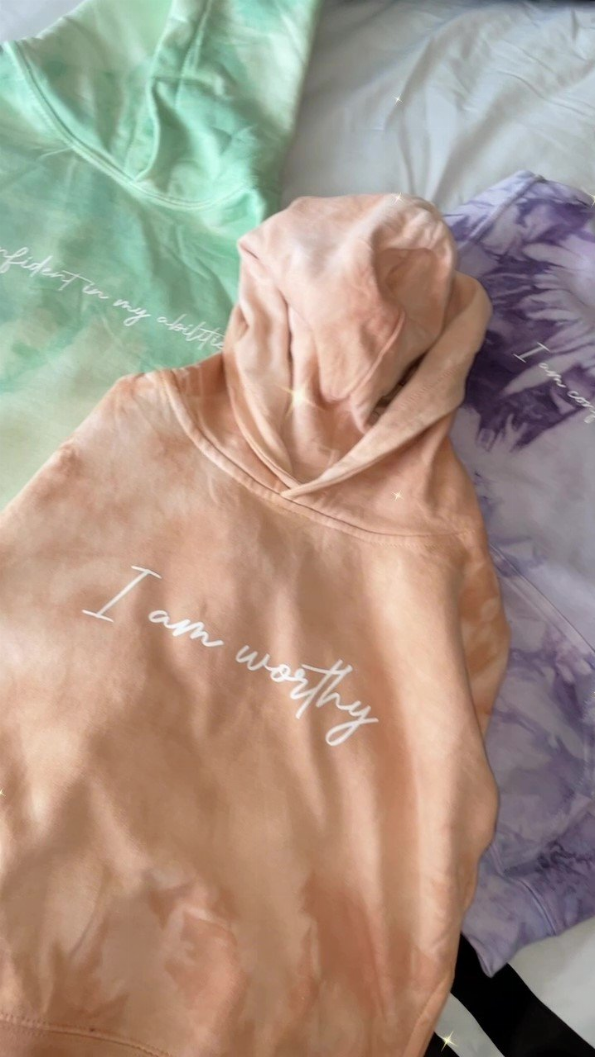 Peach and purple tie-dye hoodie shirt with white 'I am worthy' script on front