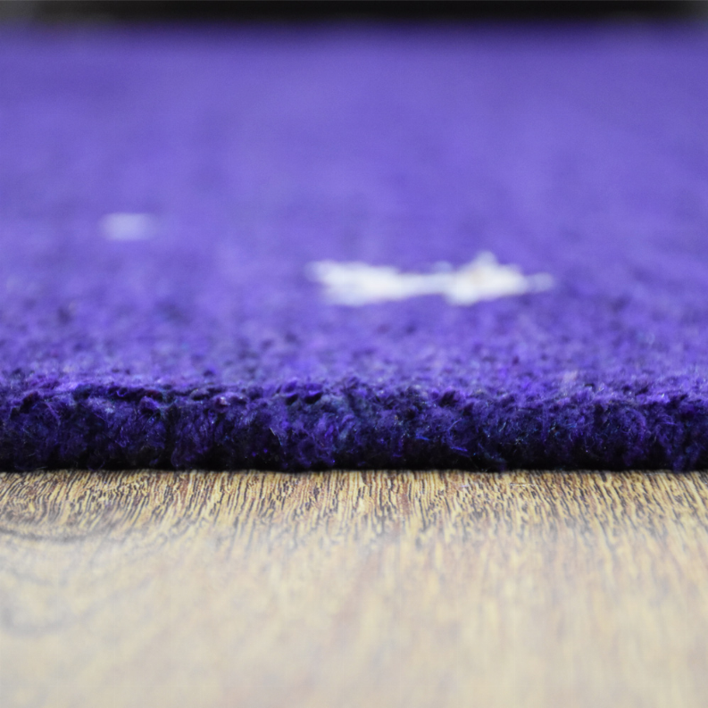 Purple rug edge close-up showing thick pile and light underside