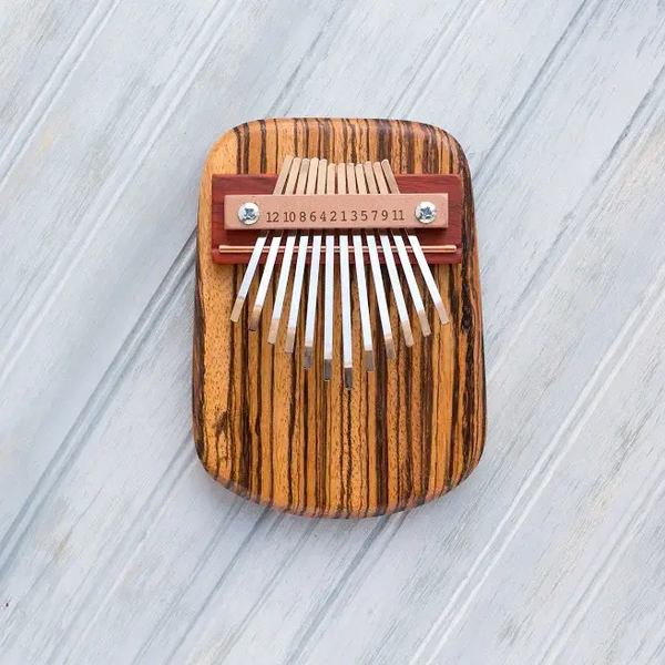 Zebrawood 12-key thumb piano with metal tines on rounded wooden soundboard