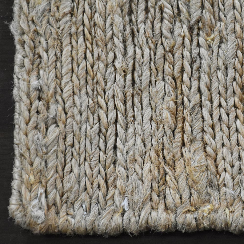 Hand woven jute rug texture close-up in light beige with tight looped pattern