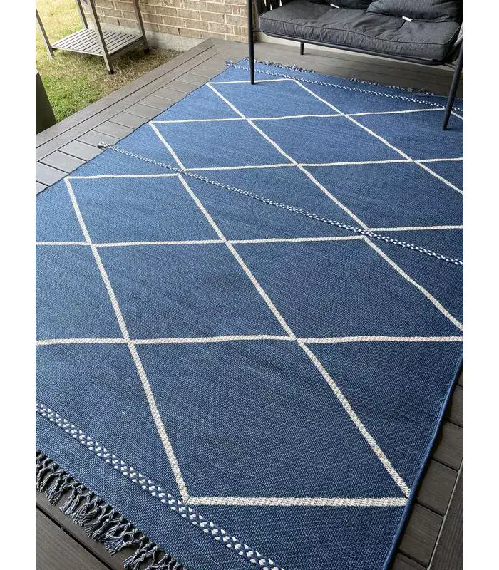 Indigo blue geometric outdoor area rug with white diamond grid and fringe trim