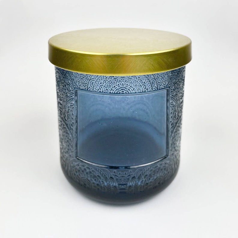 Blue floral cut-pattern candle jar with gold lid and dark front glass window