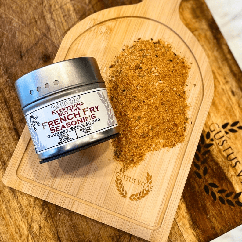 French fry seasoning tin with seasoning sprinkle on a wooden cutting board