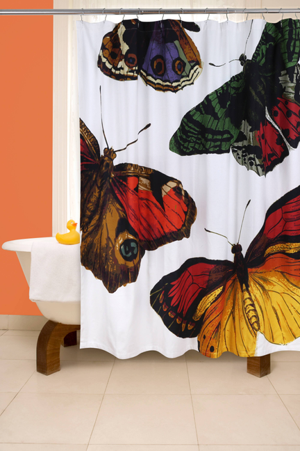 Butterfly shower curtain with vivid red, yellow, green moths on white, mounted on rod