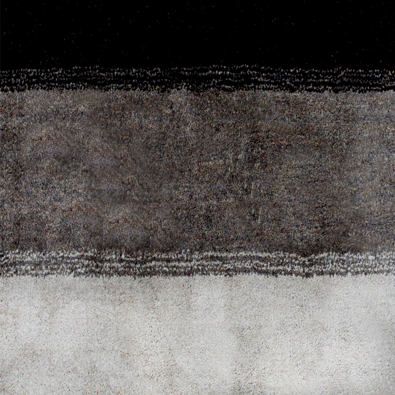 Hand-knotted area rug close-up with mottled gray and dark band plus cream border