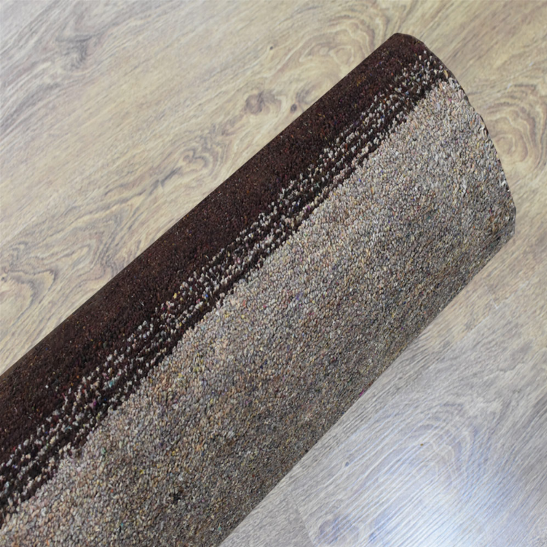 Hand-knotted area rug edge view showing dark and gray speckled stripe texture