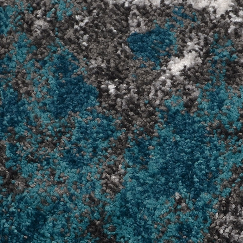 Abstract area rug texture close-up with teal and blue flecks over gray pile.