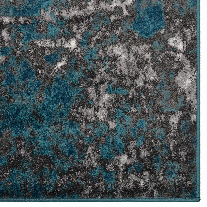 Abstract area rug corner detail with teal and gray distressed design and border.