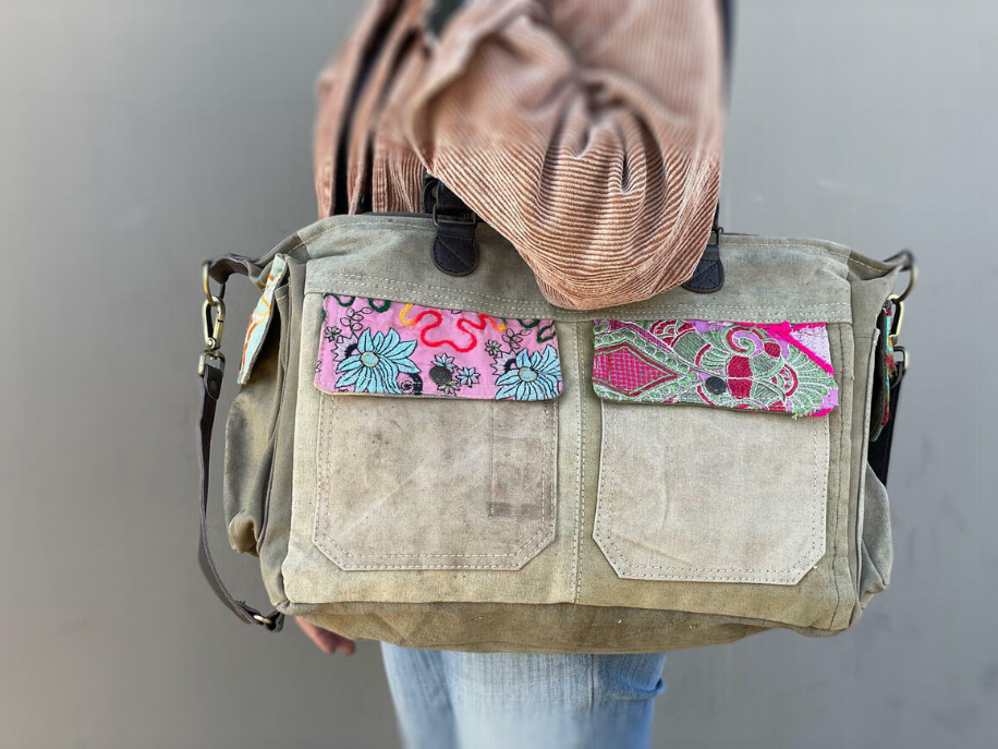 Recycled military tent shoulder bag with two front flap pockets and multicolor patch trim