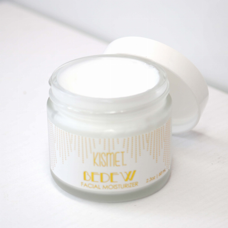 Facial moisturizer jar with white lid and gold label on clear container