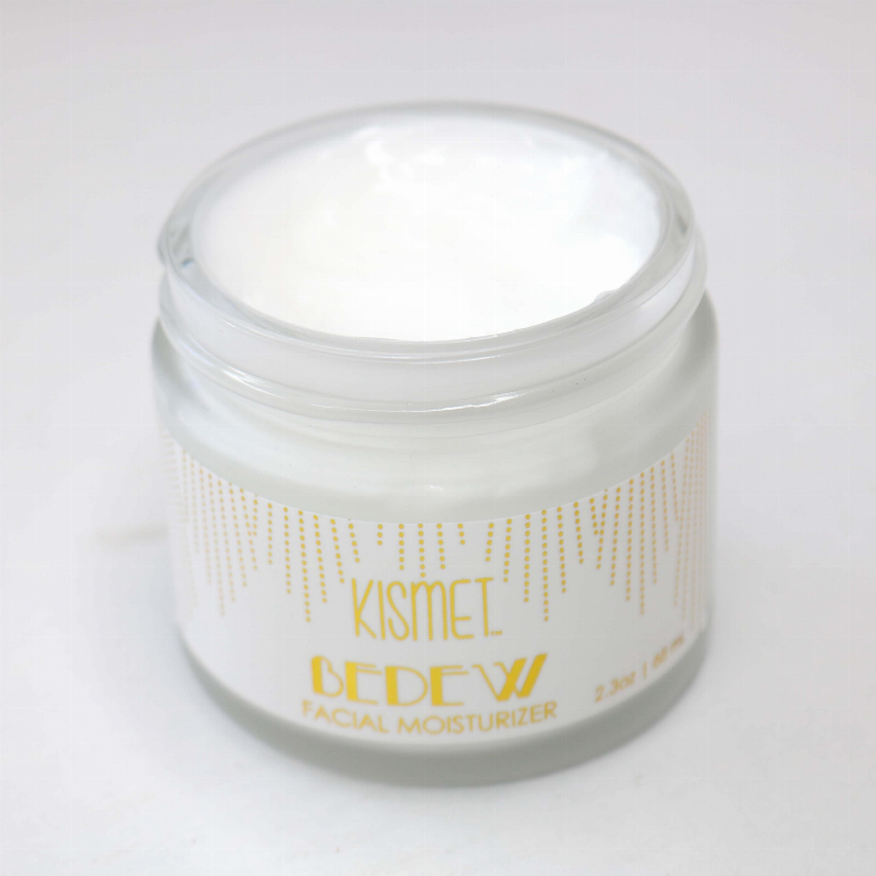 Facial moisturizer jar with white cap, gold front label, and translucent sides