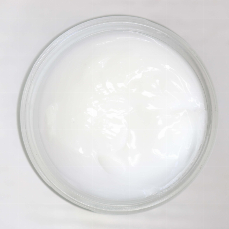 Clear jar with smooth white cream visible under the lid