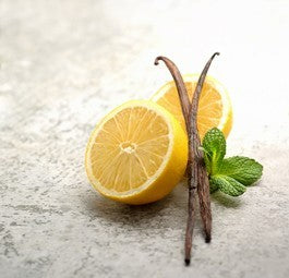 Lemon vanilla bath soak with sliced lemon, vanilla pods, and green herb