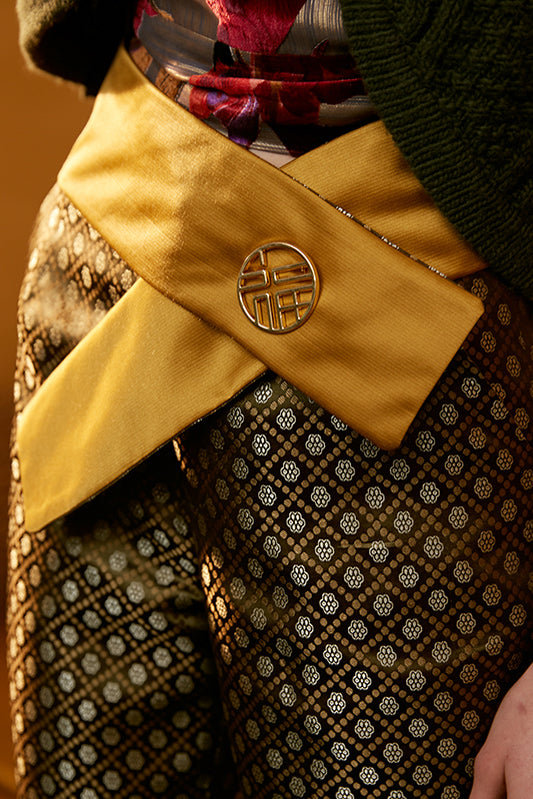 Yellow fabric belt with round gold logo clasp and diagonal panel at waist