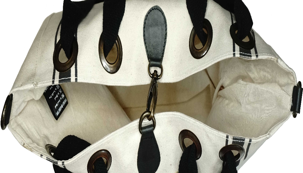 Natural canvas tote inside with pocket, black and brown strap hardware, lined interior