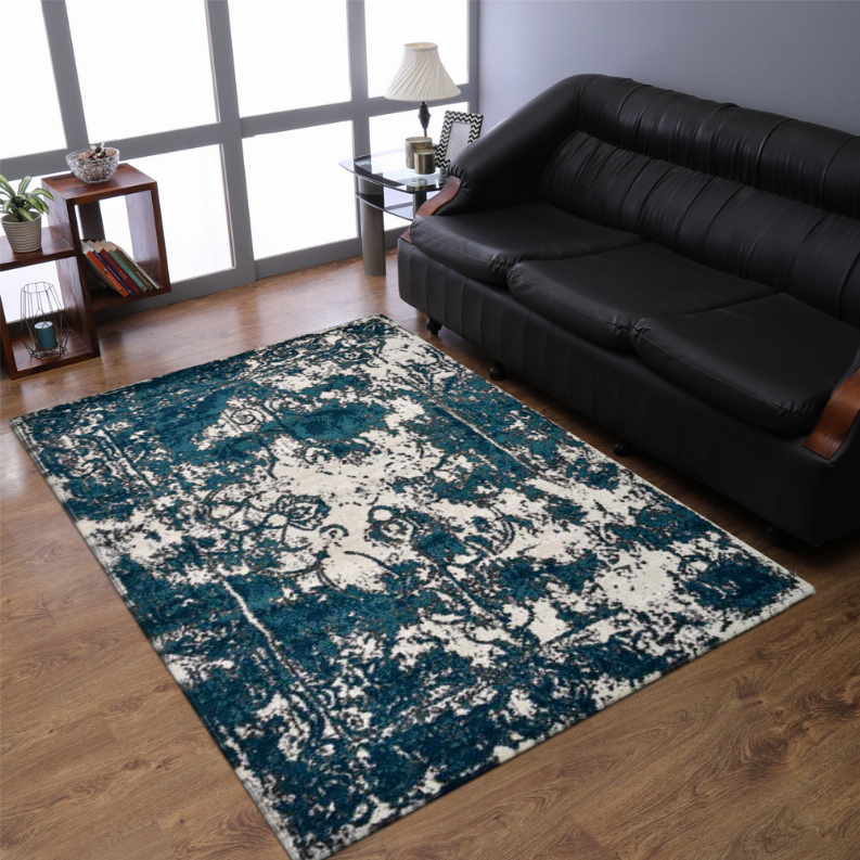 Abstract area rug with teal blue and off-white decorative pattern in living room setting