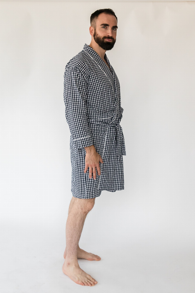 Men's navy gingham robe on model, side view with V-neck and tied waist belt, knee length