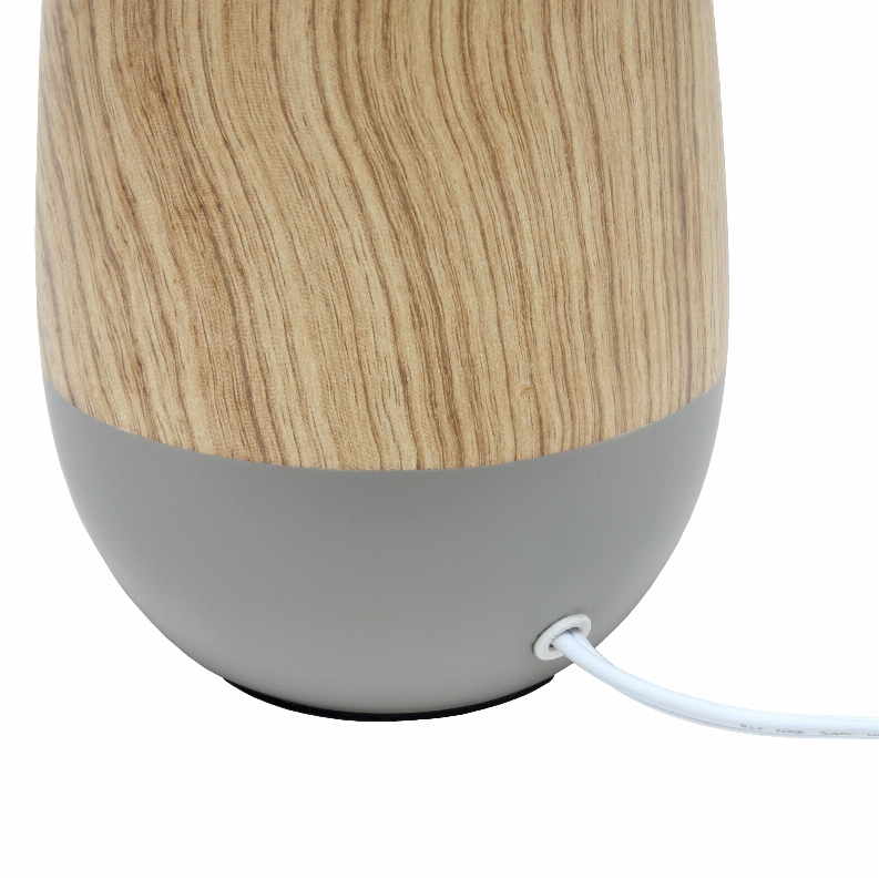Close-up of gray ceramic lamp base with light woodgrain upper section