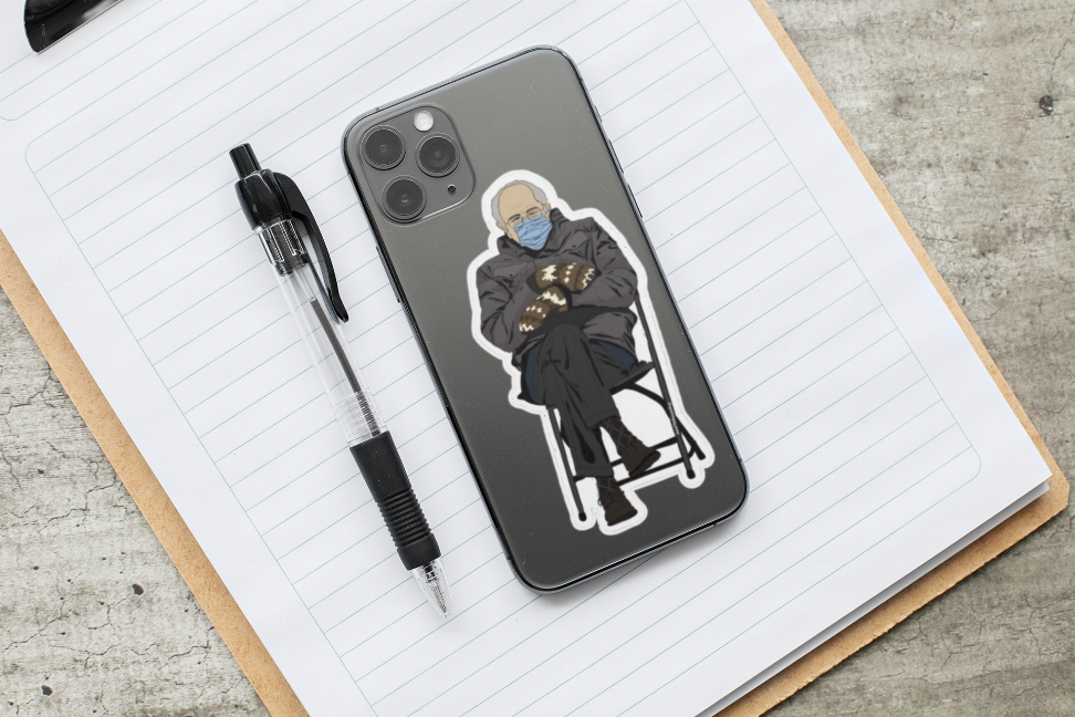 Bernie Sanders mittens sticker: seated man in winter coat and blue face mask