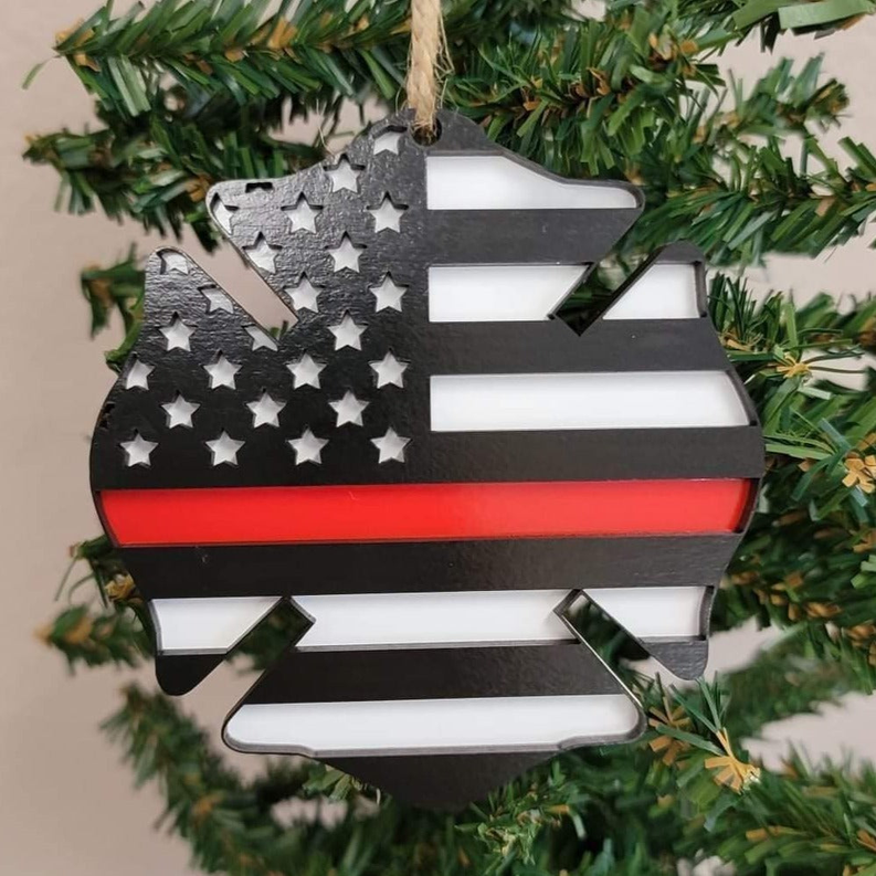 Wooden firefighter badge ornament with stars and red-white stripes, hanging on evergreen