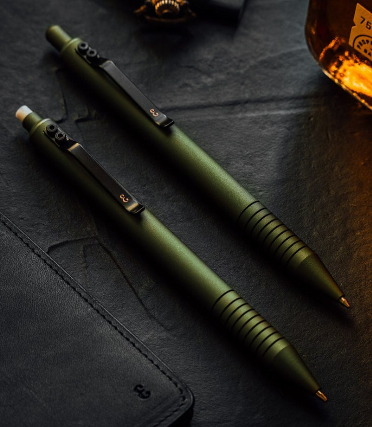 Olive green ballpoint pen with black clip and ridged grip, two pens side by side