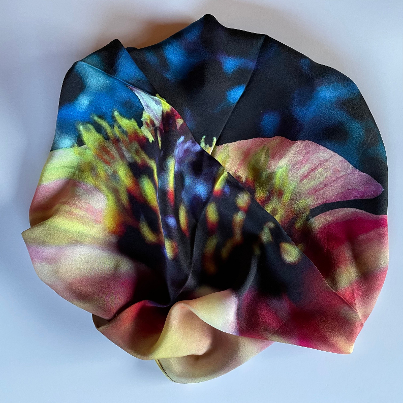 Square scarf gathered in folds with blue, green, yellow, and pink floral print