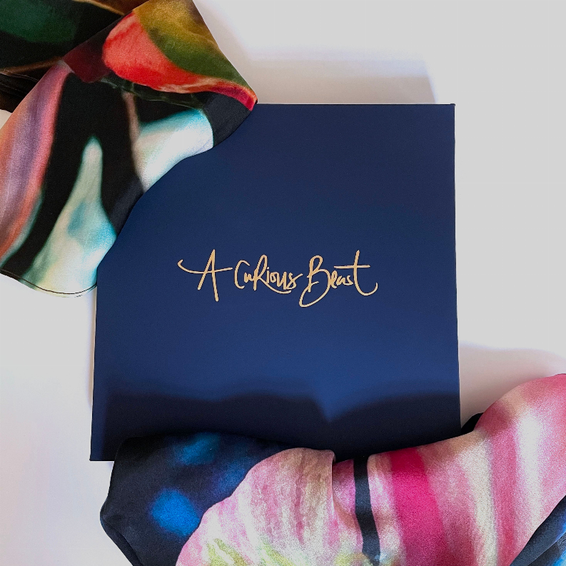 Square scarf partially shown with blue, magenta, and lime abstract floral pattern