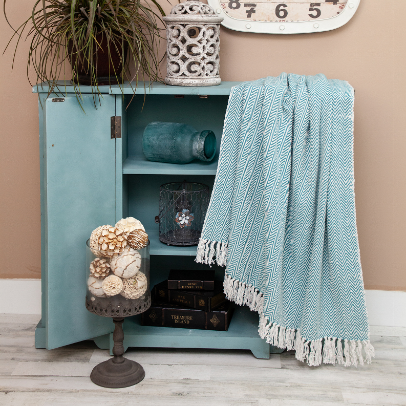 Cotton throw blanket with teal zigzag weave and white fringed edges