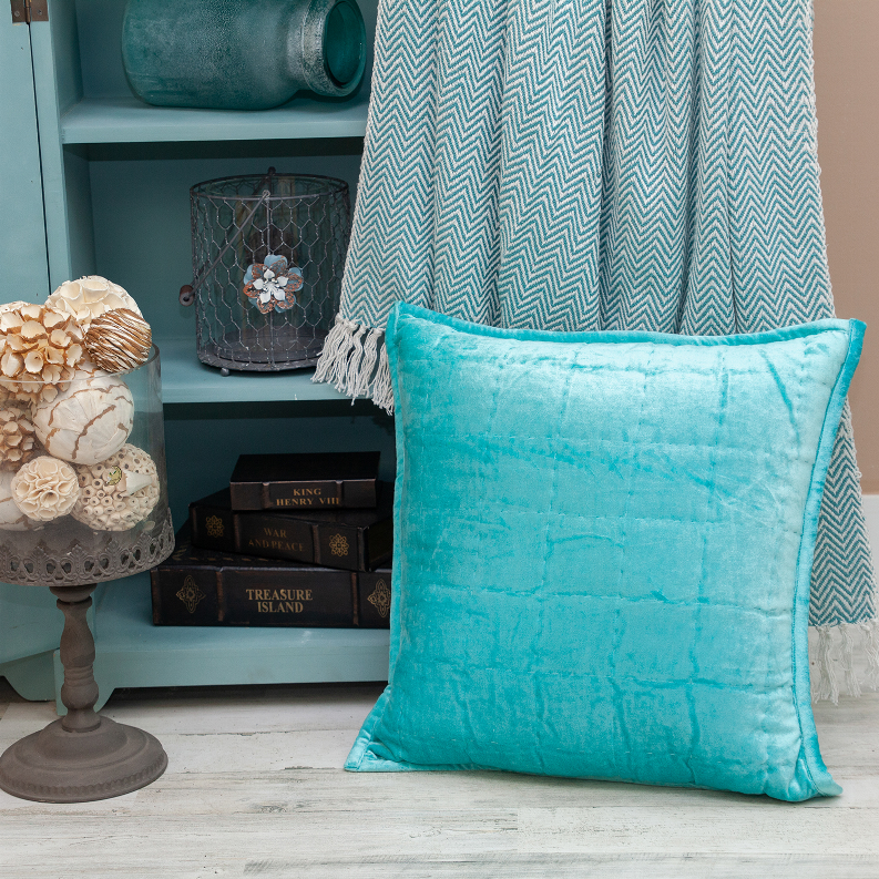 Aqua quilted throw pillow displayed with soft fringed accents and square shape