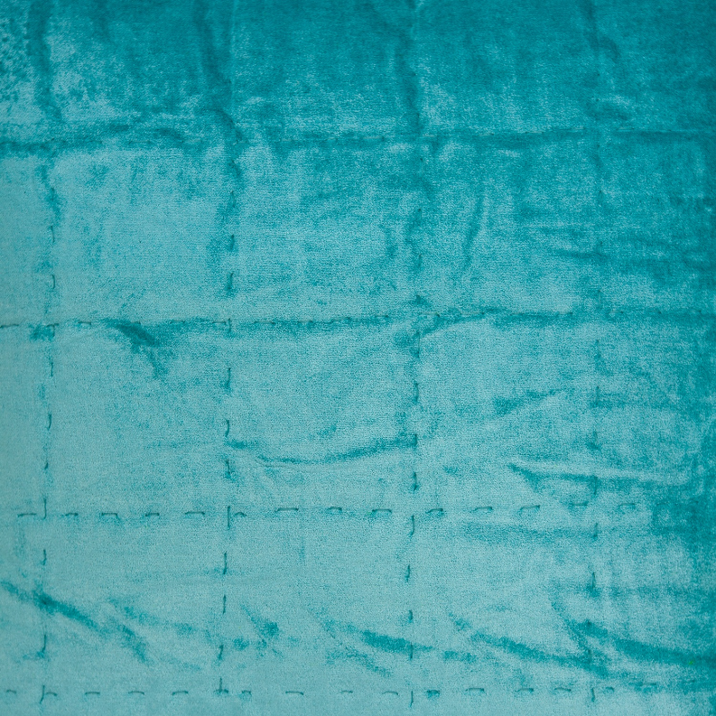 Close-up of aqua pillow fabric with textured quilt stitching pattern