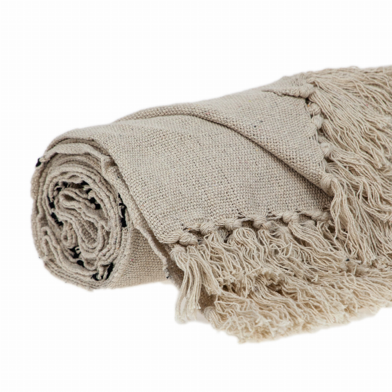 Beige woven handloom throw rolled up, textured fabric with long fringe