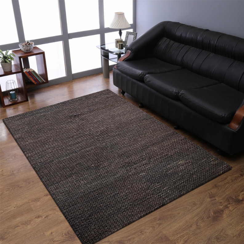 Hand-woven jute area rug, dark charcoal brown, solid rectangular weave on wood flooring