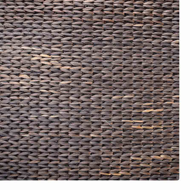 Hand-woven jute area rug close-up, dark charcoal with lighter tan fiber highlights