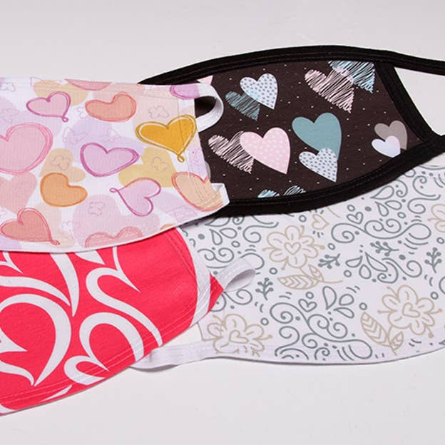 Flat face mask with heart print panel and dark lining; red and white patterned fabric
