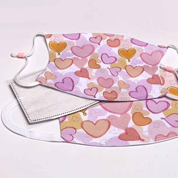 Flat face mask with multicolor pastel hearts print, white trim, and elastic ear loops