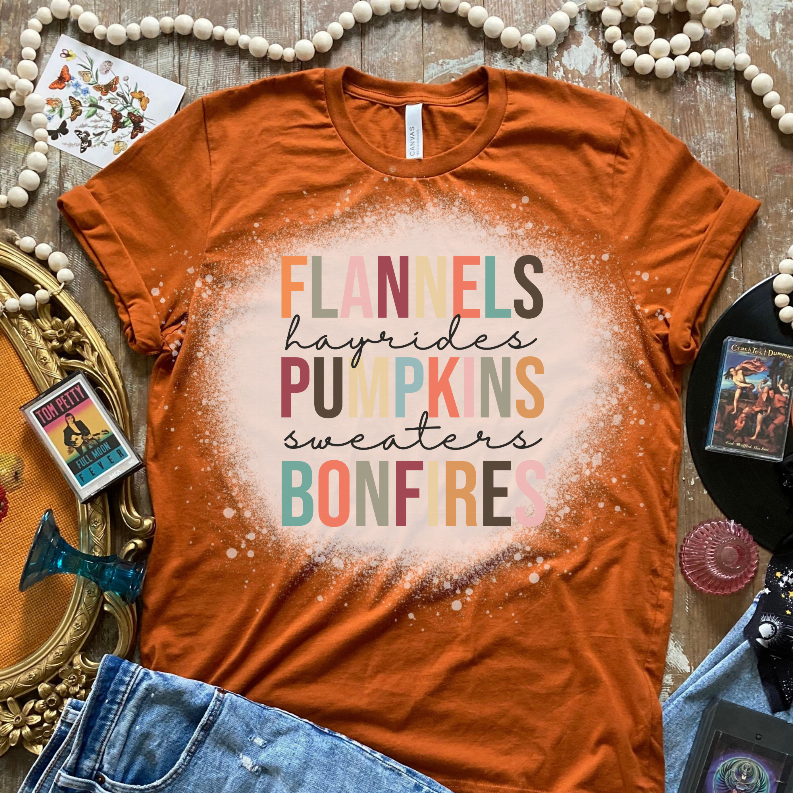 Orange short-sleeve crewneck T-shirt with centered speckled multicolor flannels pumpkins bonfires