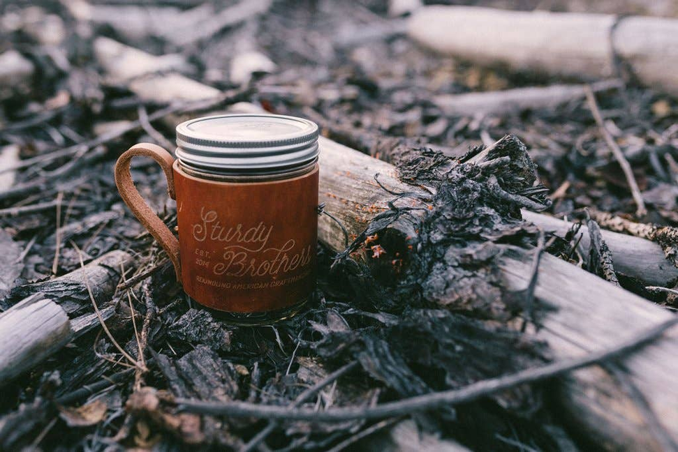 Rustic coffee mug jar with metal lid, brown 'Sturdy Brother' text