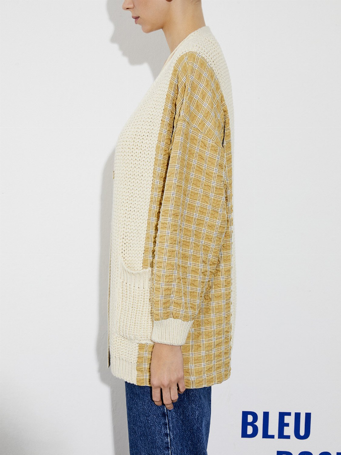 Cream knit cardigan with yellow plaid sleeves and ribbed cuff detail
