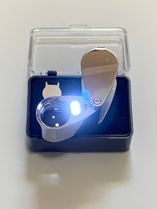 LED jeweler loupe with illuminated glass lens in clear-lid black storage case